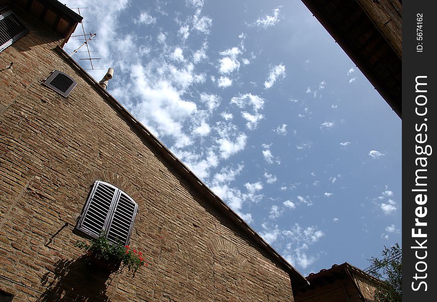 Image of an window with flowers and beautiful blue cloudy sky