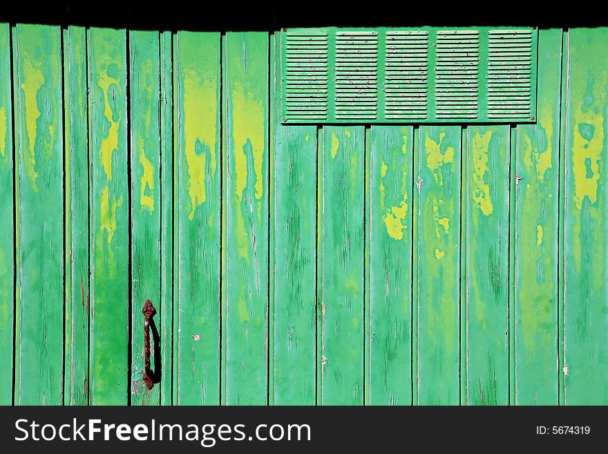 Old green and yellow garage door, crusty and rusty. Old green and yellow garage door, crusty and rusty