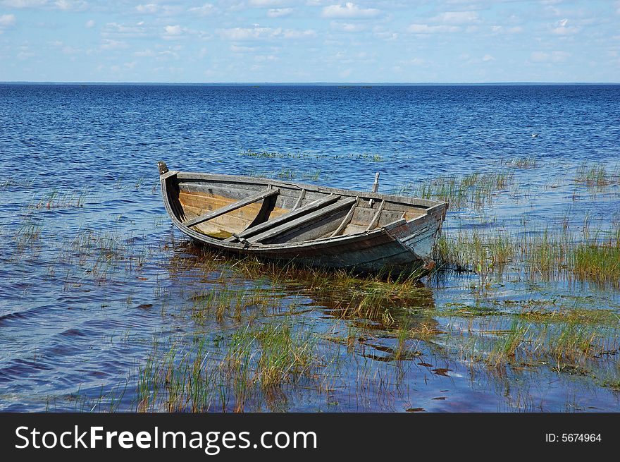 Old wooden fishing boat near the lake bank, north Russia. Old wooden fishing boat near the lake bank, north Russia