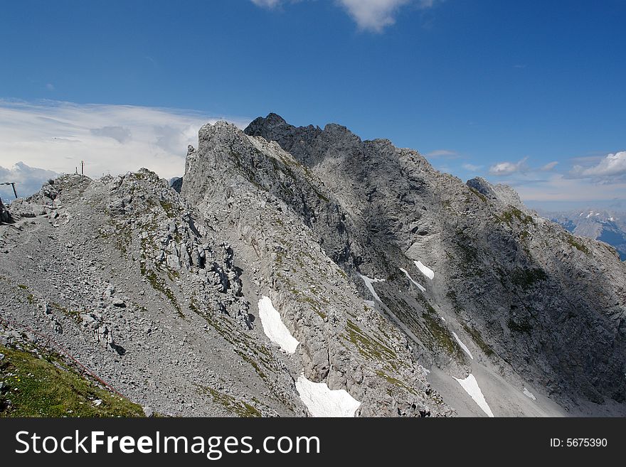 Clouds above the mountains Austrian  Alpes . The snow on the rocks. Sight from the peak of Hafelkarspitze mountain .Not so far from Innsbruck  . Clouds above the mountains Austrian  Alpes . The snow on the rocks. Sight from the peak of Hafelkarspitze mountain .Not so far from Innsbruck  .