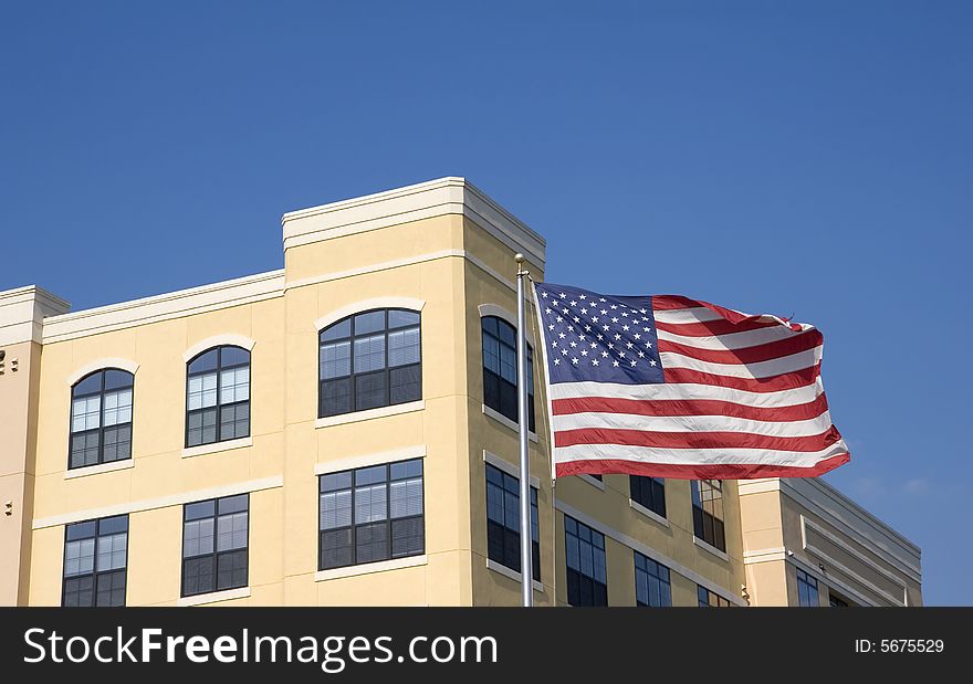 Yellow stucco loft apartments on blue sky with american flag. Yellow stucco loft apartments on blue sky with american flag