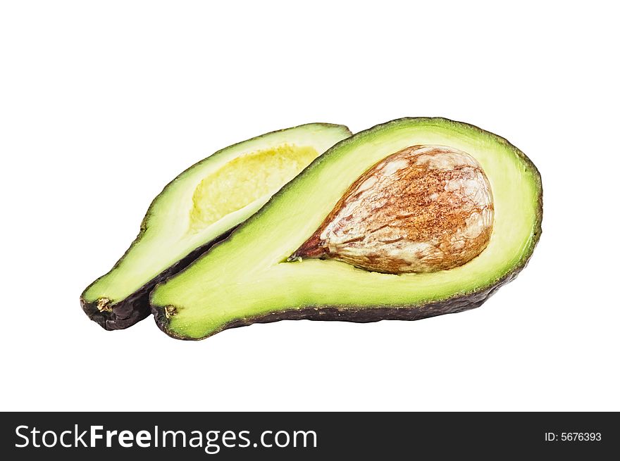 An avocado cut in two pieces, white background. Clipping path provided. An avocado cut in two pieces, white background. Clipping path provided.
