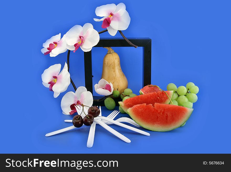 Flower an orchid, fruit and white plastic forks. Flower an orchid, fruit and white plastic forks