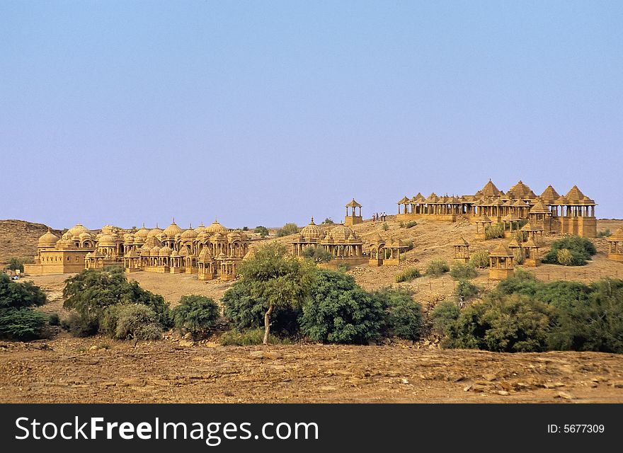 Established on a semi desert hill, very richly decorated sculpted and carved in yellow sandstone thees cenotaphs are usually constructed with pillars, arches and dome in Mogul style in memoriam of ancient rulers of the rich city of Jaisalmer, Rajasthan, India. Established on a semi desert hill, very richly decorated sculpted and carved in yellow sandstone thees cenotaphs are usually constructed with pillars, arches and dome in Mogul style in memoriam of ancient rulers of the rich city of Jaisalmer, Rajasthan, India.