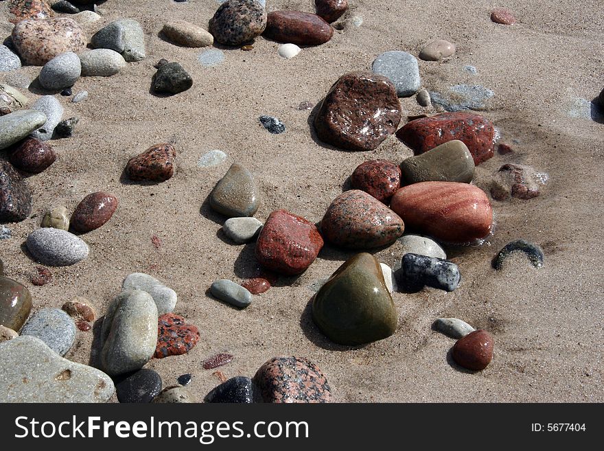 Stones in the sand by the sea. Stones in the sand by the sea.