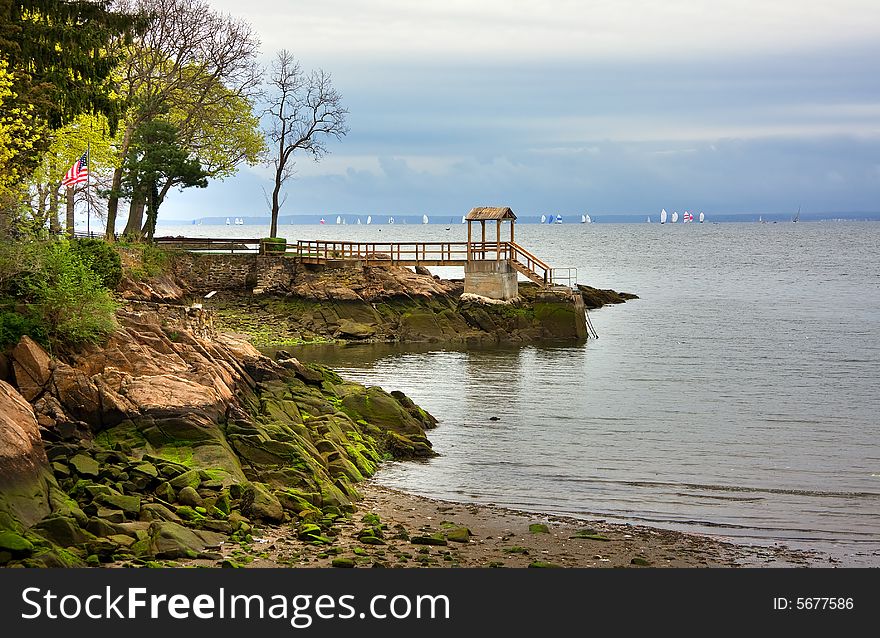 Seascape of rocky shore with distant sail boats. Seascape of rocky shore with distant sail boats.