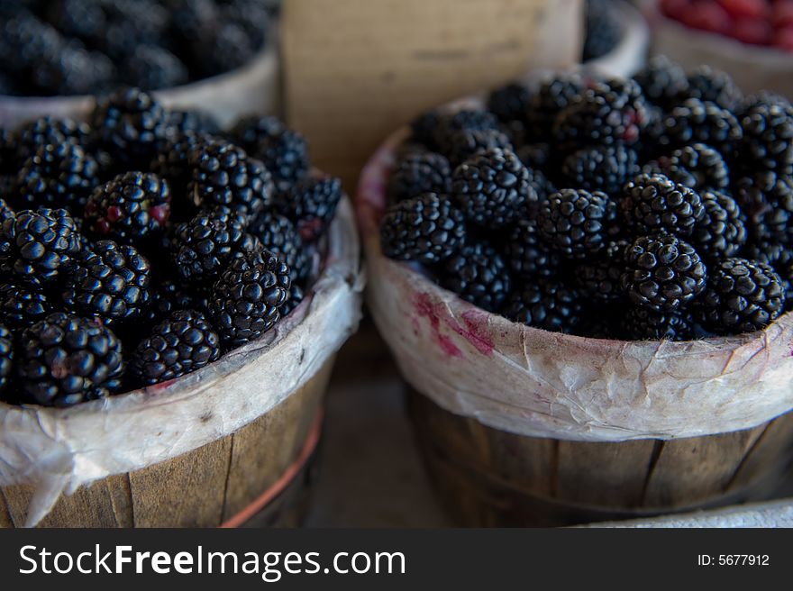 An image of bushels overflowing with fresh blackberries. An image of bushels overflowing with fresh blackberries