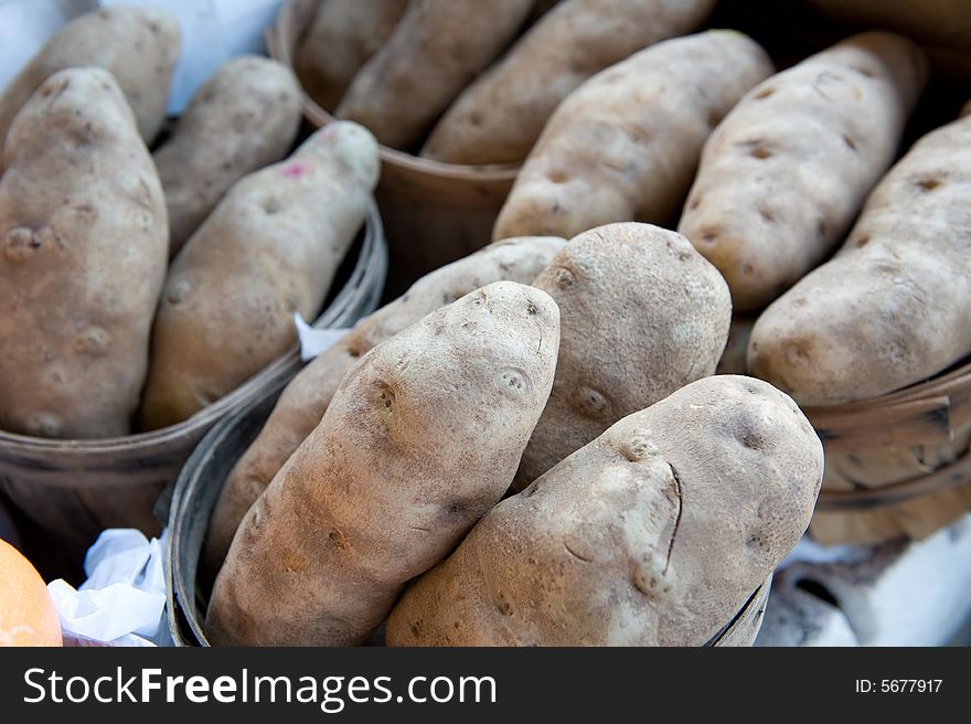 An image of large Idaho potatoes displayed at a farmer's market. An image of large Idaho potatoes displayed at a farmer's market