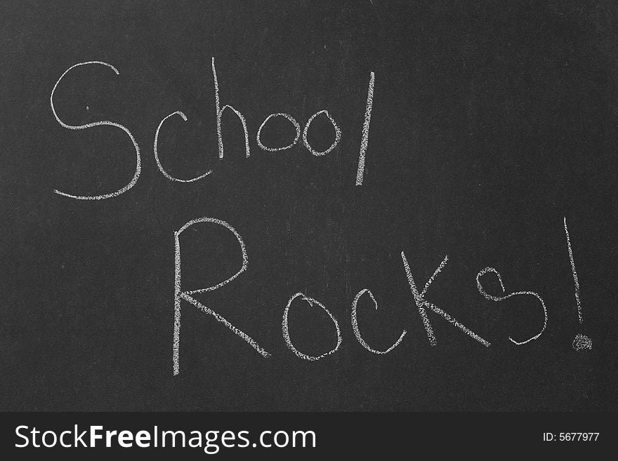 A third grader's hand writing on an old school black board. A third grader's hand writing on an old school black board.