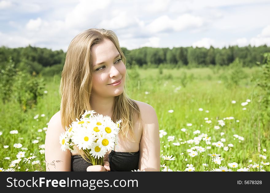 Young Woman With Flowers On The Meadow