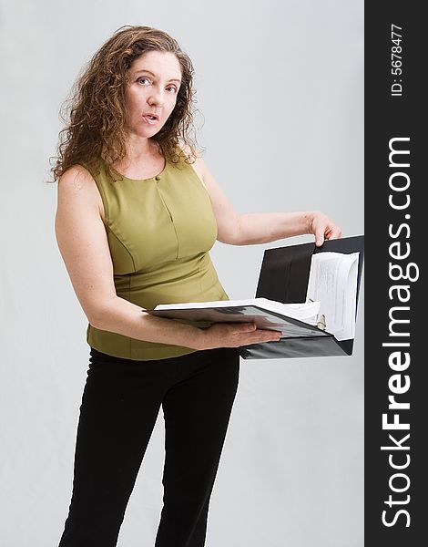 Business woman dressed in a green shirt and black pants holding binder, isolated