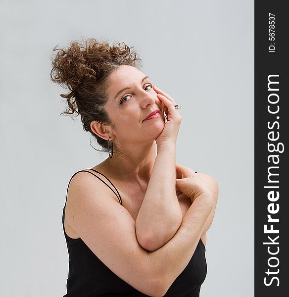 Serene woman with hand in face supporting her head and her hair up, isolated