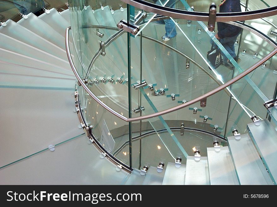 Looking down through a transparent staircase that spirals around. Looking down through a transparent staircase that spirals around