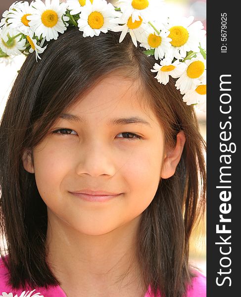 Little girl with crown of daisies on head