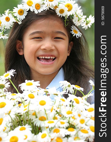 Beautiful little girl with crown of daisies