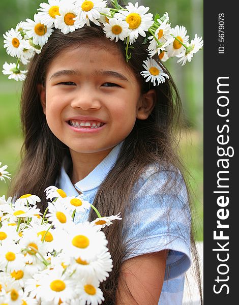 Beautiful little girl with crown of daisies  on head