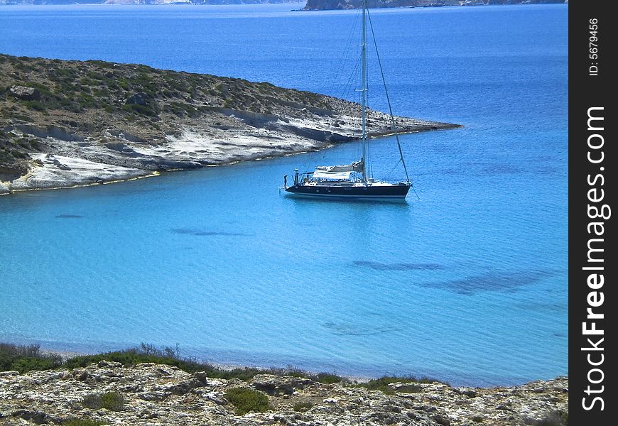Large sailboat sitting in a cove of Poliegos Island. Large sailboat sitting in a cove of Poliegos Island.
