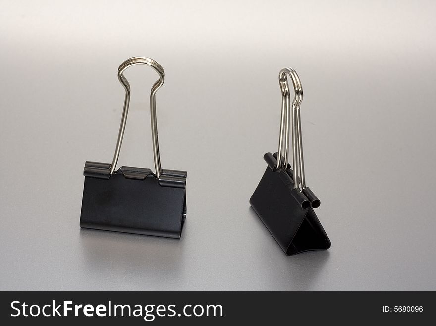 Two paper clip on silver background