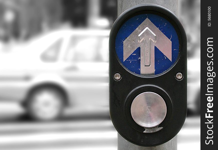 At a pedestrian crossing, showing button to push to activate pedestrian crossing.