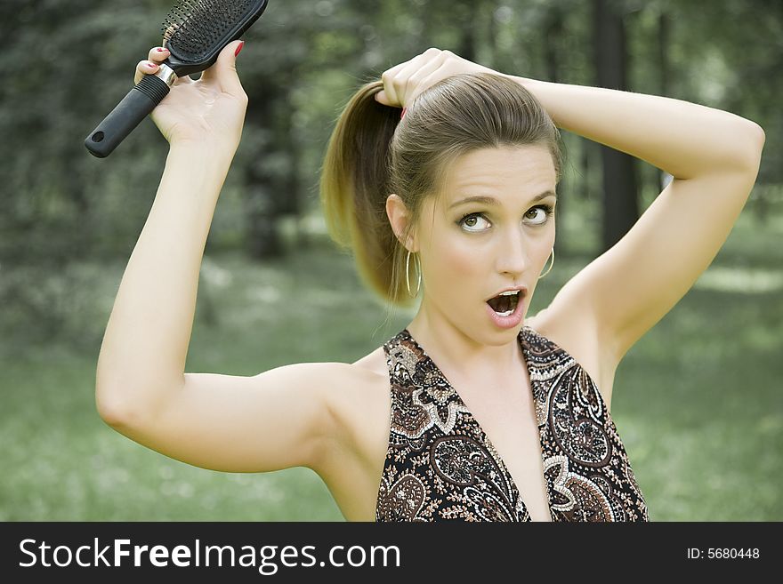 Young Woman With Comb Outdoors. Young Woman With Comb Outdoors