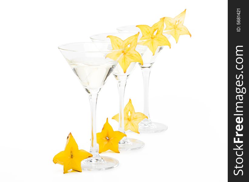 Glass of martini and slice of carambola on a white background. Glass of martini and slice of carambola on a white background