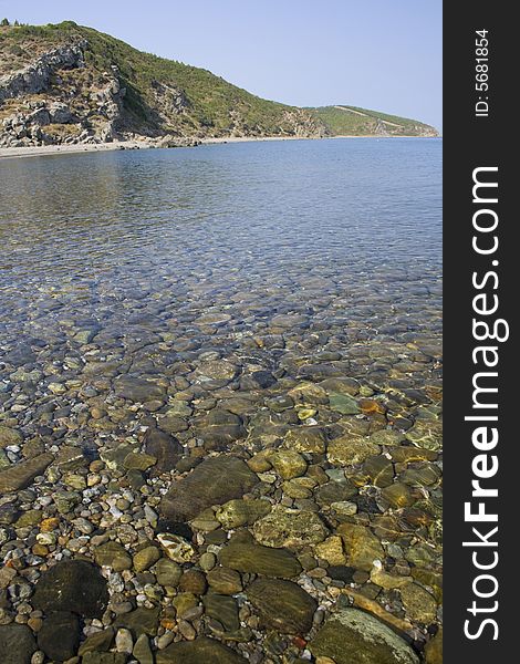 View of pebbles under water and mountains. View of pebbles under water and mountains