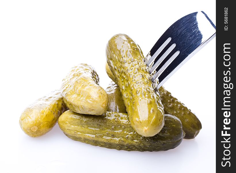 Crackling pickled gherkins on a plug on a white background