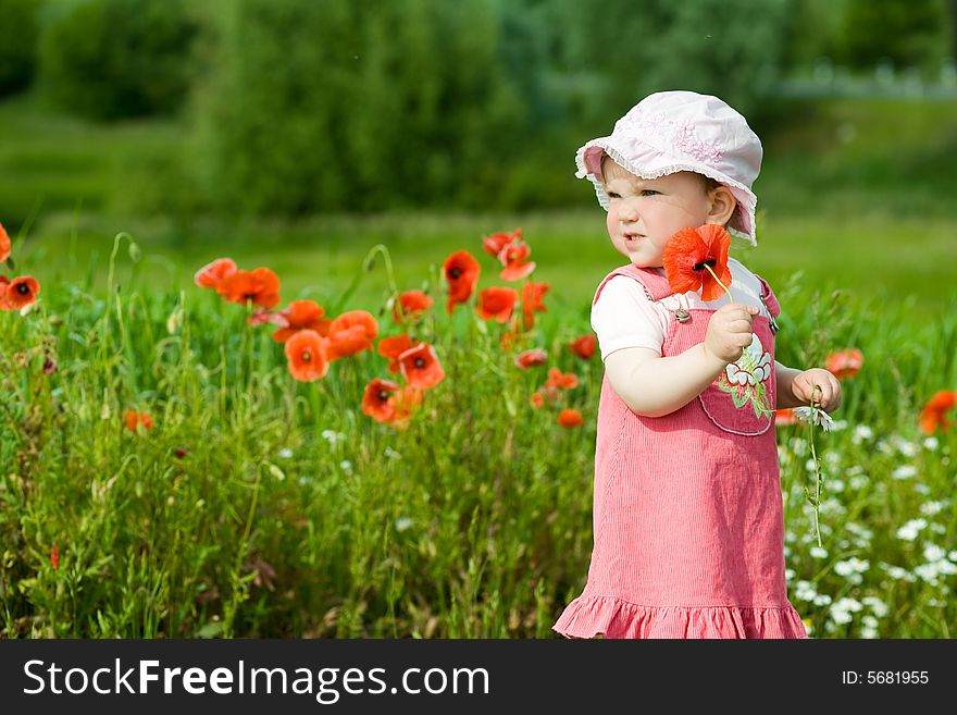 An image of baby-girl amongst green field with red poppies. An image of baby-girl amongst green field with red poppies