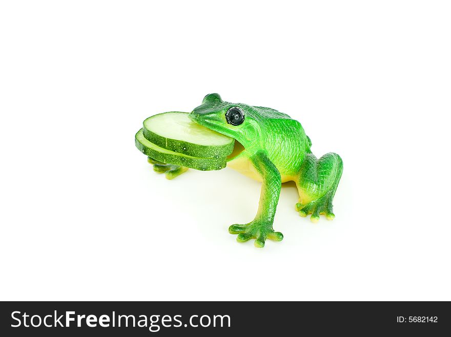 Toy frog with two cucumber slices in mouth isolated on the white background