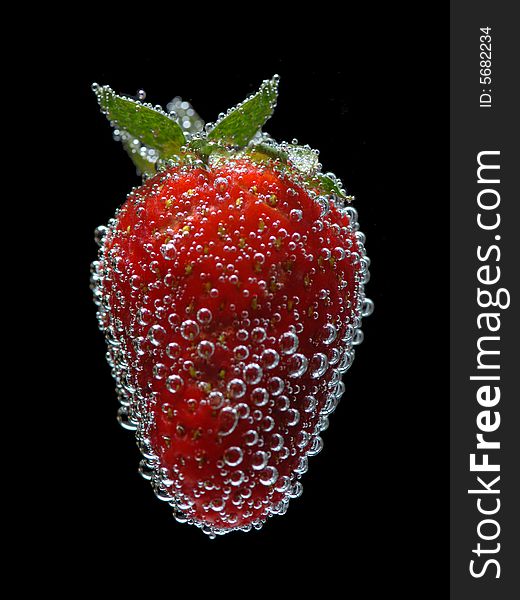 Strawberry in water on black background