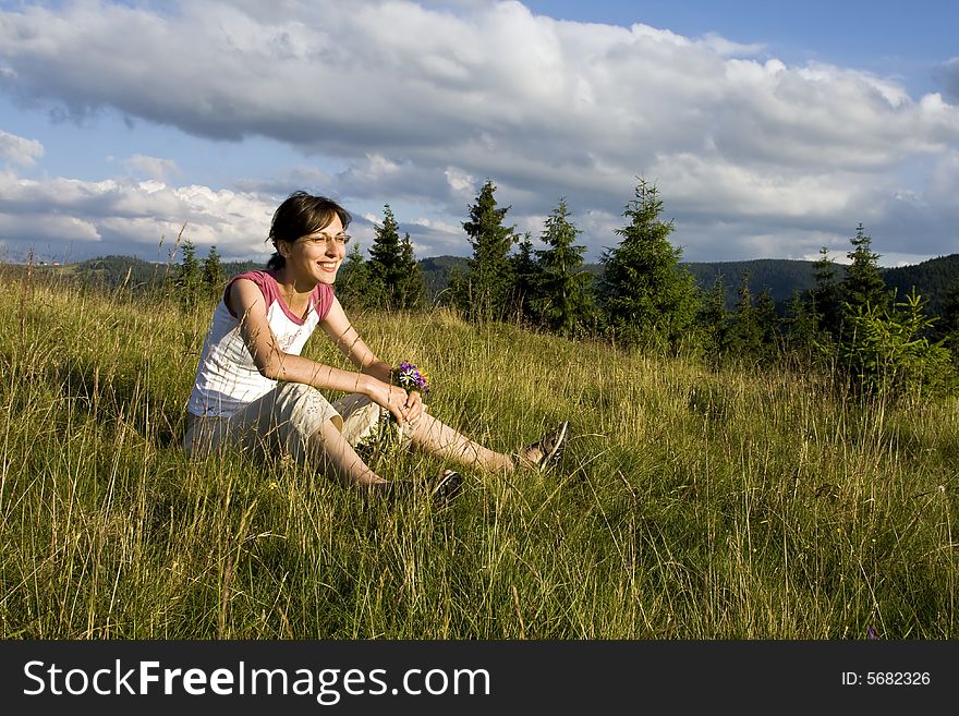 Young woman with wild flowers in meadow. Young woman with wild flowers in meadow