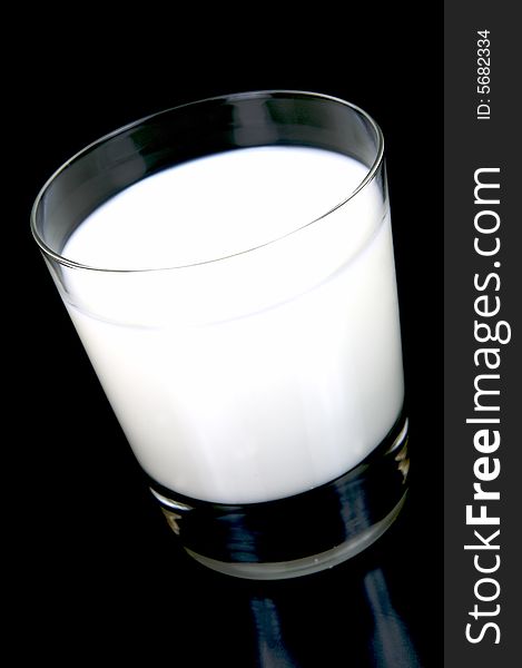A glass of milk isolated against a black background. A glass of milk isolated against a black background