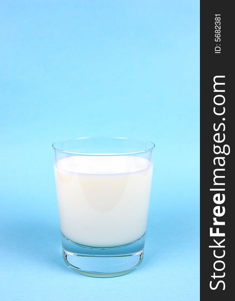 A glass of milk isolated against a blue background. A glass of milk isolated against a blue background