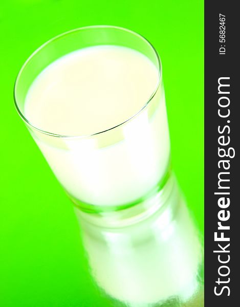 A glass of milk isolated against a green background. A glass of milk isolated against a green background