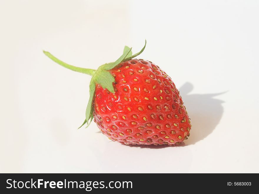 Single red ripe strawberry against white background