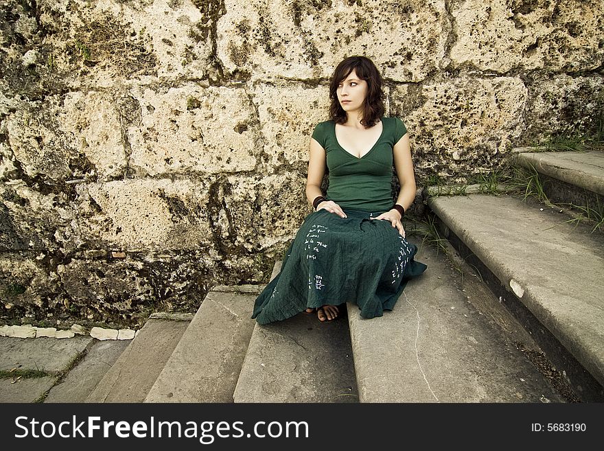 Sad young woman sited in antique stone steps. Sad young woman sited in antique stone steps.