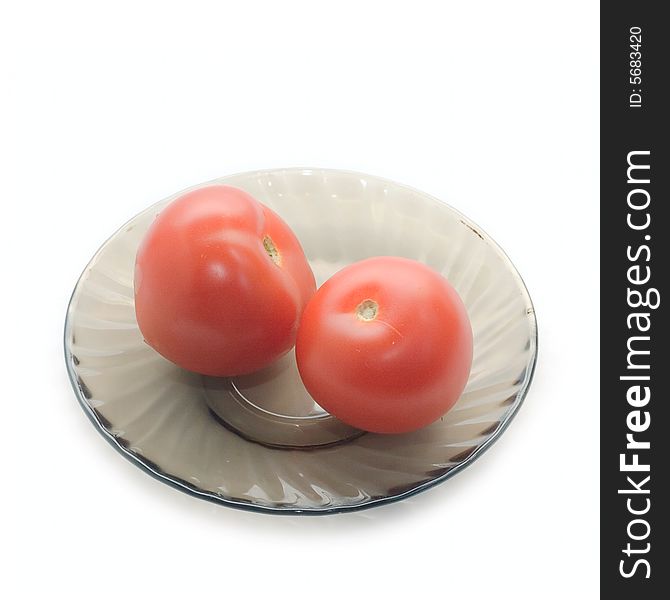 Two tomatoes on dark plate isolated on white for your design
