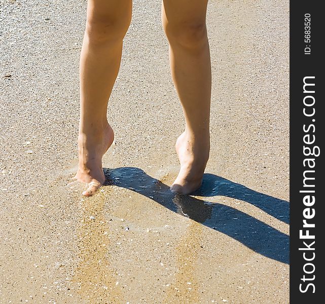 Child legs on sand with shadow for your design