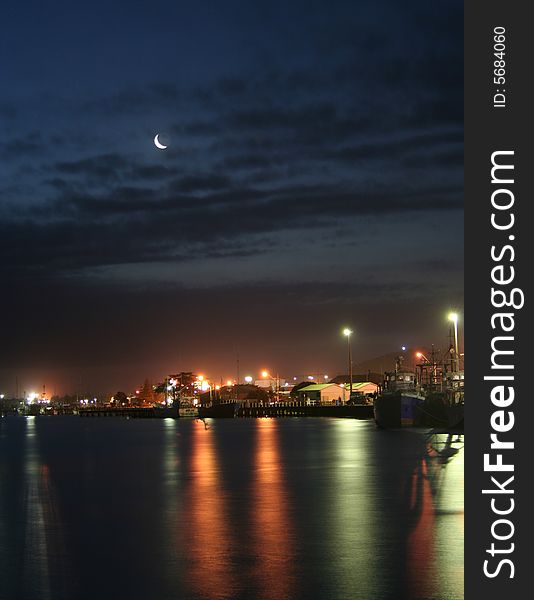 Reflections in calm water of fishing village at night. Reflections in calm water of fishing village at night.