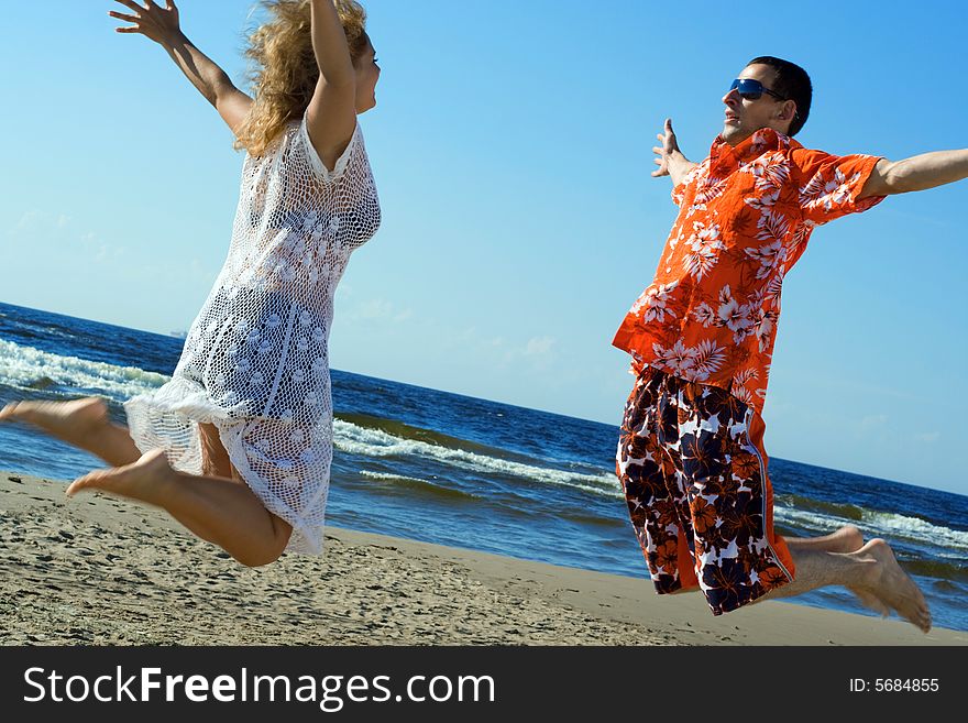 Two young people jumping on the beach. Two young people jumping on the beach.