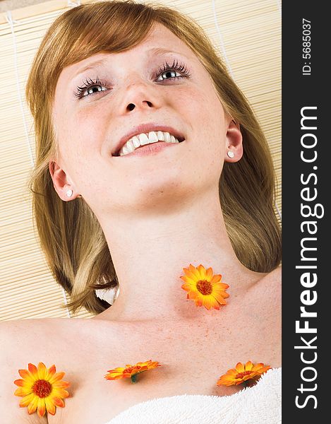 Young beautiful woman in a spa with a towel and flowers. Young beautiful woman in a spa with a towel and flowers