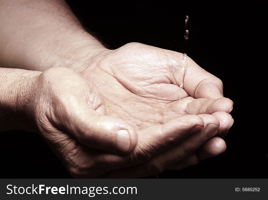 Photo of an old male hands with water