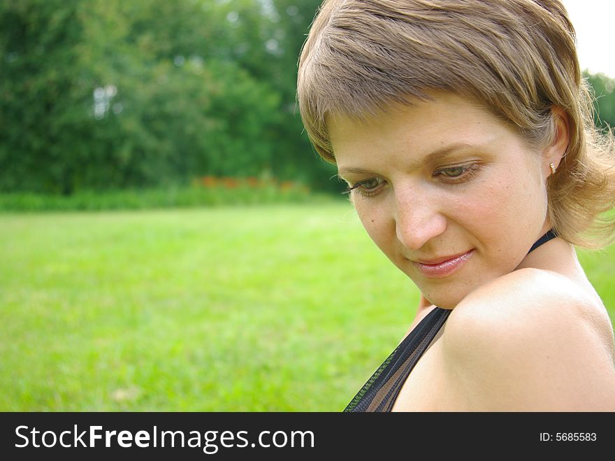 Attractive Young Woman On The Green Grass