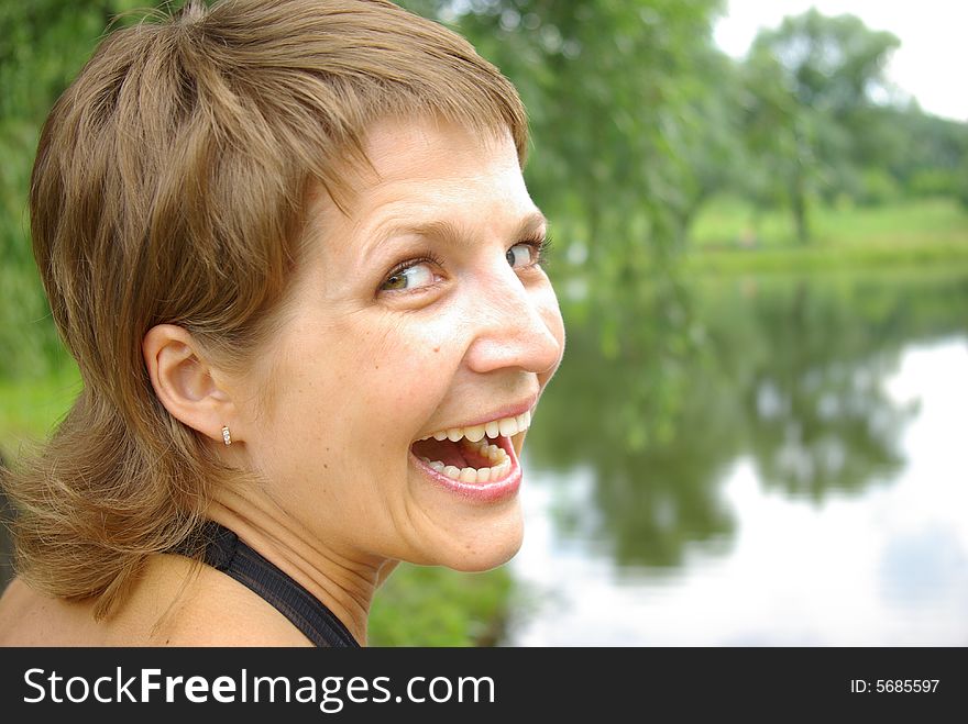 Attractive young woman smiling against a lake