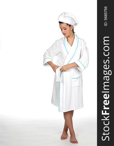 Teen tying belt of her white robe and wearing a towel on her hair