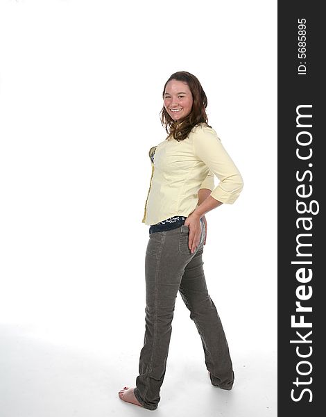 Woman standing on high key background with hand on hip. Woman standing on high key background with hand on hip