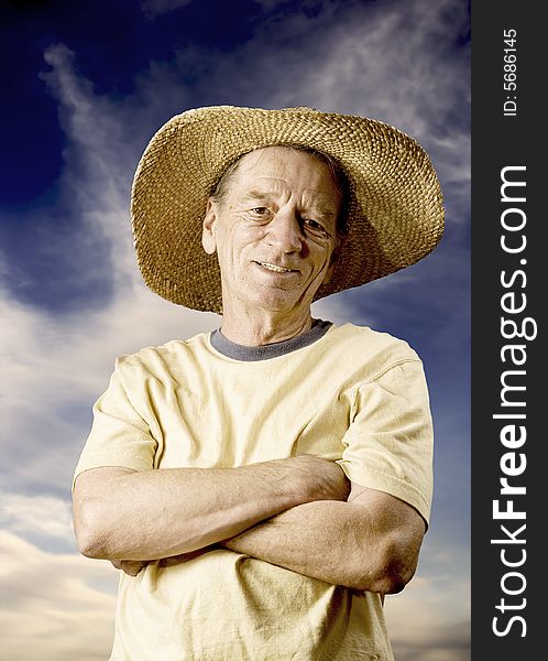 Senior man in a straw hat in front of cloudy sky. Senior man in a straw hat in front of cloudy sky