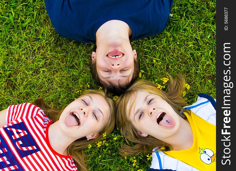 Three Friends Lay On A Grass