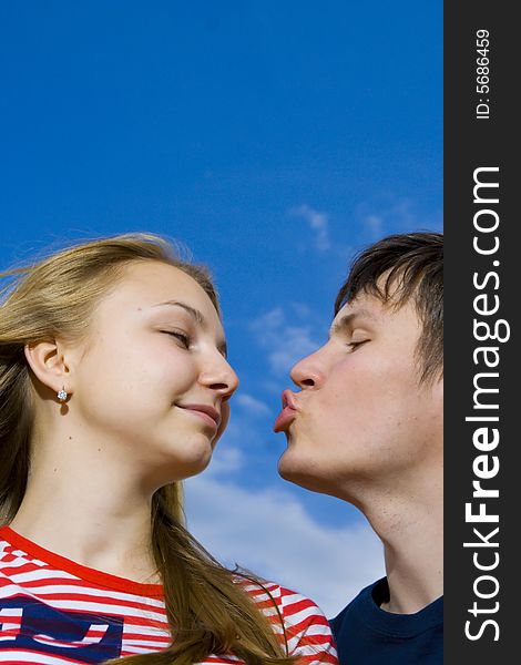 Kissing couple on a background of the blue sky