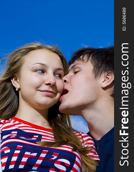 Kissing Couple On A Background Of The Blue Sky